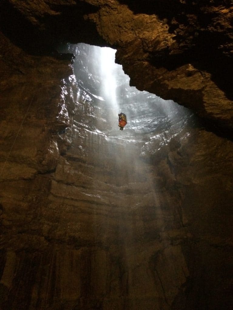 Person being lowered into cave